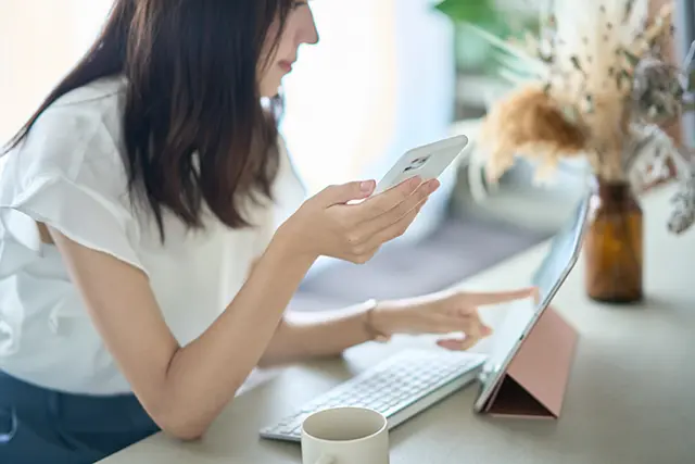 PCとスマホで探す女性