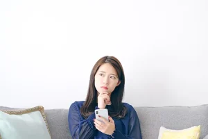 スマホを見て慰問を持つ女性