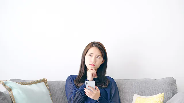 スマホを見て慰問を持つ女性