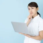 パソコンを見ながら悩む看護師