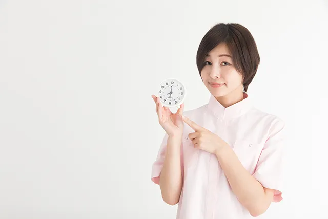 時計を手に説明をする看護師