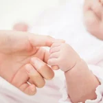 赤ちゃんの手を持つ母の手