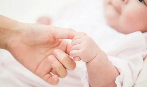 赤ちゃんの手を持つ母の手