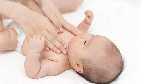 赤ちゃんをタッチケアする女性の手
