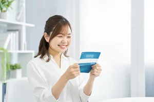 通帳を見て微笑む女性